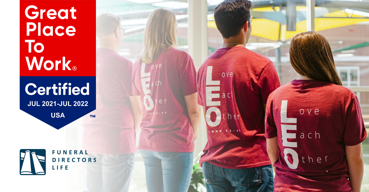 employees standing with "Love Each Other" shirts